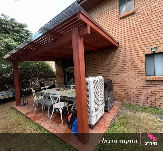 פרגולה מעץ עם שולחן וכיסאות בגינה
